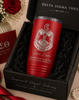 Red tumbler with Delta Sigma Theta logo in a gift box, surrounded by decorative items.