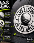 Trucker hat front patch close-up with golf ball texture and 'I Like Putting In The Hole' text