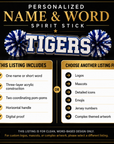 Personalized acrylic spirit stick with bold “TIGERS” text and blue pom-poms