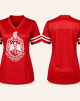 A red short-sleeve athletic-style V-neck jersey shown from both front and back on a light beige background. The front features a large white crest with Greek letters and a torch graphic, and the sleeves have white stripes.