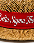 Straw hat with red band featuring Delta Sigma Theta script embroidery