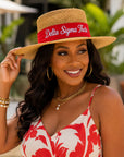 Straw hat worn by a woman; red band with Delta Sigma Theta script
