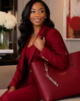 Woman in crimson blazer carrying red tote bag with Delta Sigma Theta silver Greek letter keychain charm