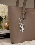 Delta Sigma Theta DST silver monogram keychain charm clipped to taupe tote bag