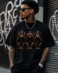 Streetwear lifestyle mockup of black graphic t-shirt with hear no evil see no evil speak no evil monkey artwork