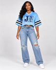 Model wearing Jackson State Tigers Block Letter Carolina blue cropped mesh football jersey with jeans