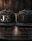 Jackson State Black Camo New Era 9FIFTY hats comparing Black Silver and Tone-on-Tone Black Block JSU leatherette patch finishes