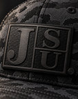 Close-up of tone-on-tone black Block JSU laser-engraved leatherette patch on Jackson State Black Camo New Era hat