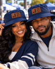 Black couple wearing Jackson State Tigers Dress Blue Navy outdoor bucket hats with walnut leatherette JSU patches