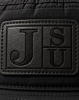 Close-up of tonal black leatherette Jackson State JSU patch on black bucket hat
