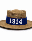 A woven straw fedora-style hat with a wide brim and a dark blue band around the crown, featuring the white number '1914' printed prominently on the band.