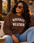Black woman wearing Chocolate Brown Whiskey Weather crewneck sweatshirt in an autumn lifestyle setting