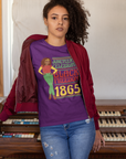 Purple Juneteenth T-shirt worn by woman; 'Black Freedom 1865' front graphic