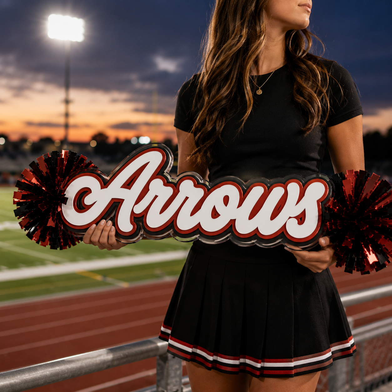 Personalized acrylic spirit stick with cursive red-and-white text and red pom-poms