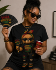 Black T-shirt with teddy bear graphic wearing a cap, bow tie, and colorful Juneteenth designs
