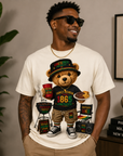 White T-shirt with teddy bear graphic holding a plate, surrounded by Juneteenth 1865 patches