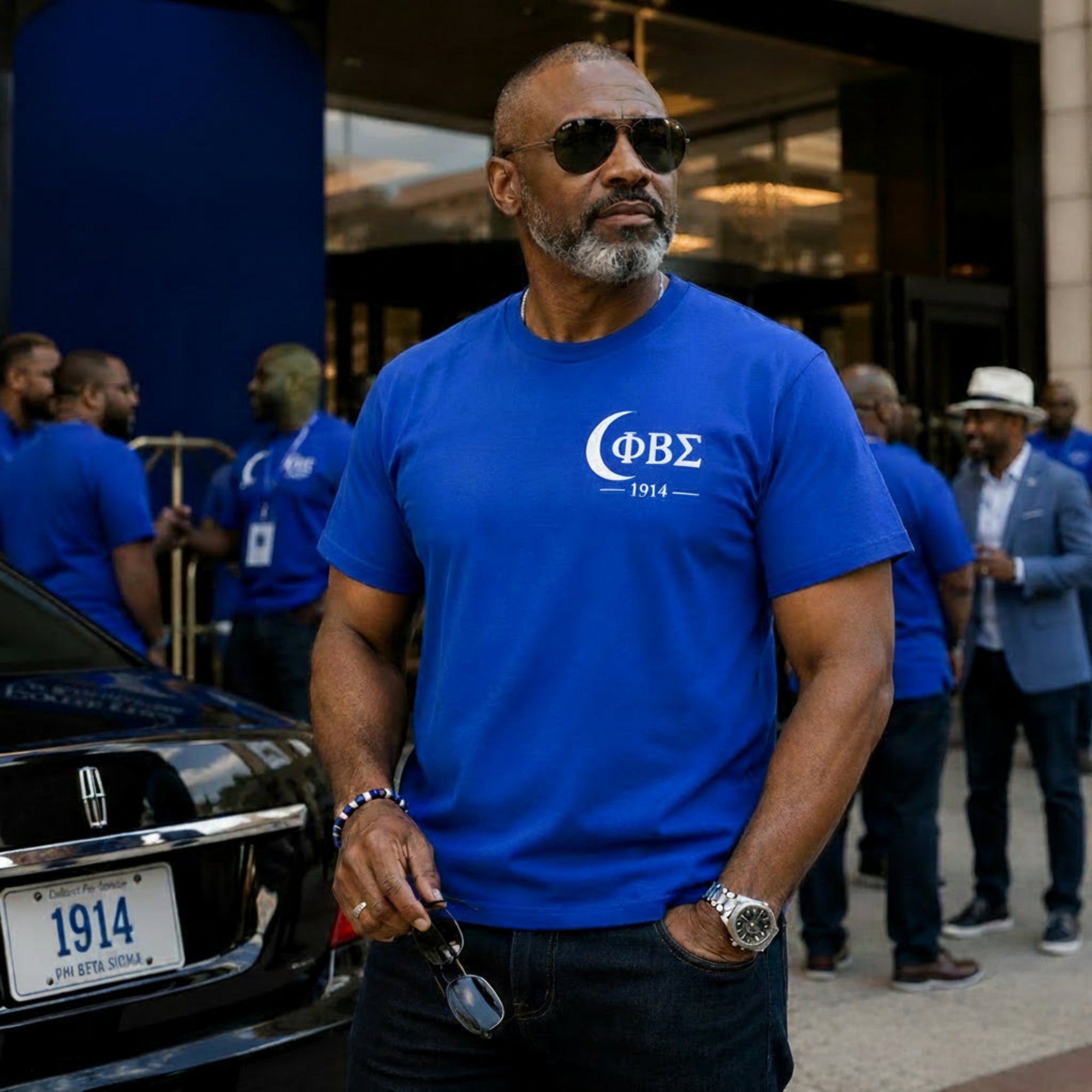 Phi Beta Sigma 1914 t-shirt worn by Black professional man outside luxury hotel during fraternity conference weekend