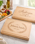 Two personalized wooden cutting boards on a kitchen counter with food items.