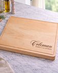 Wooden cutting board with engraved text on a marble countertop