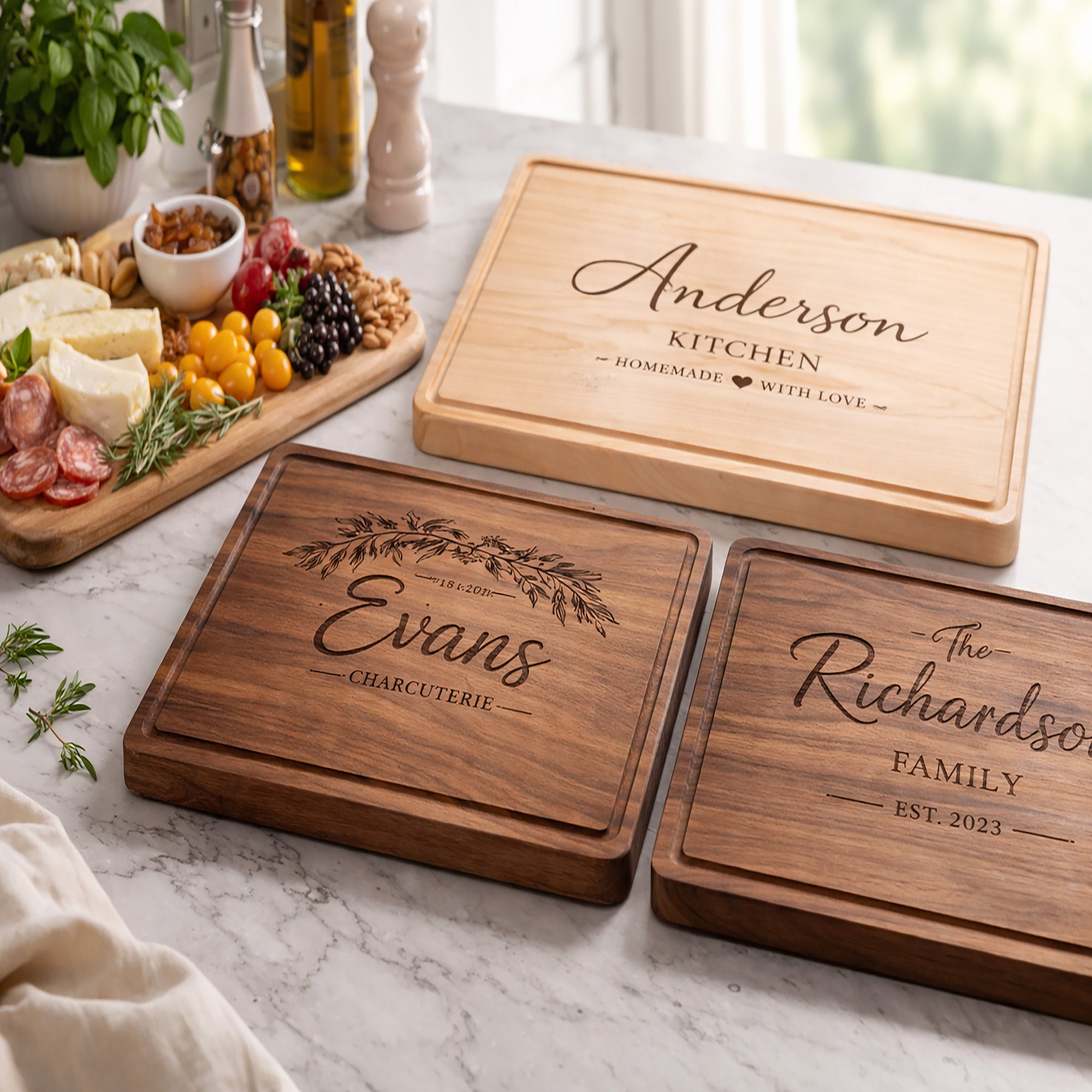 Three wooden cutting boards with engraved names on a marble surface.