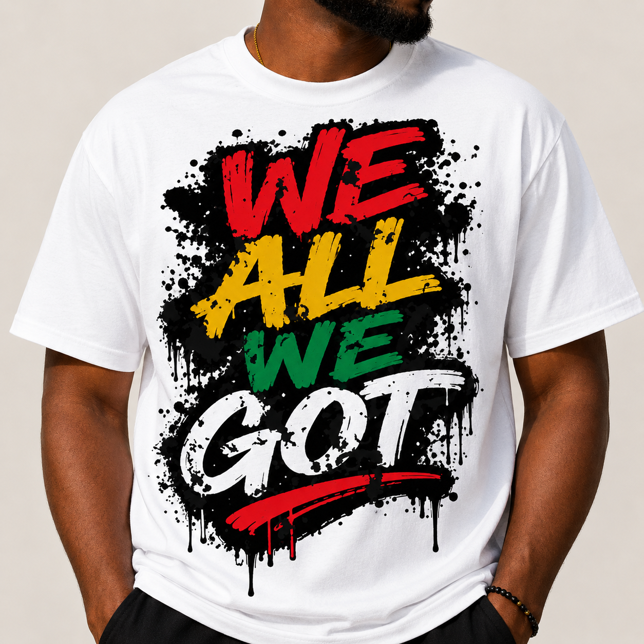 White Juneteenth graphic T-shirt with splatter “WE ALL WE GOT” front text