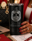 Black tumbler with Delta Sigma Theta sorority logo held by a hand, with laptop and notebook in background.