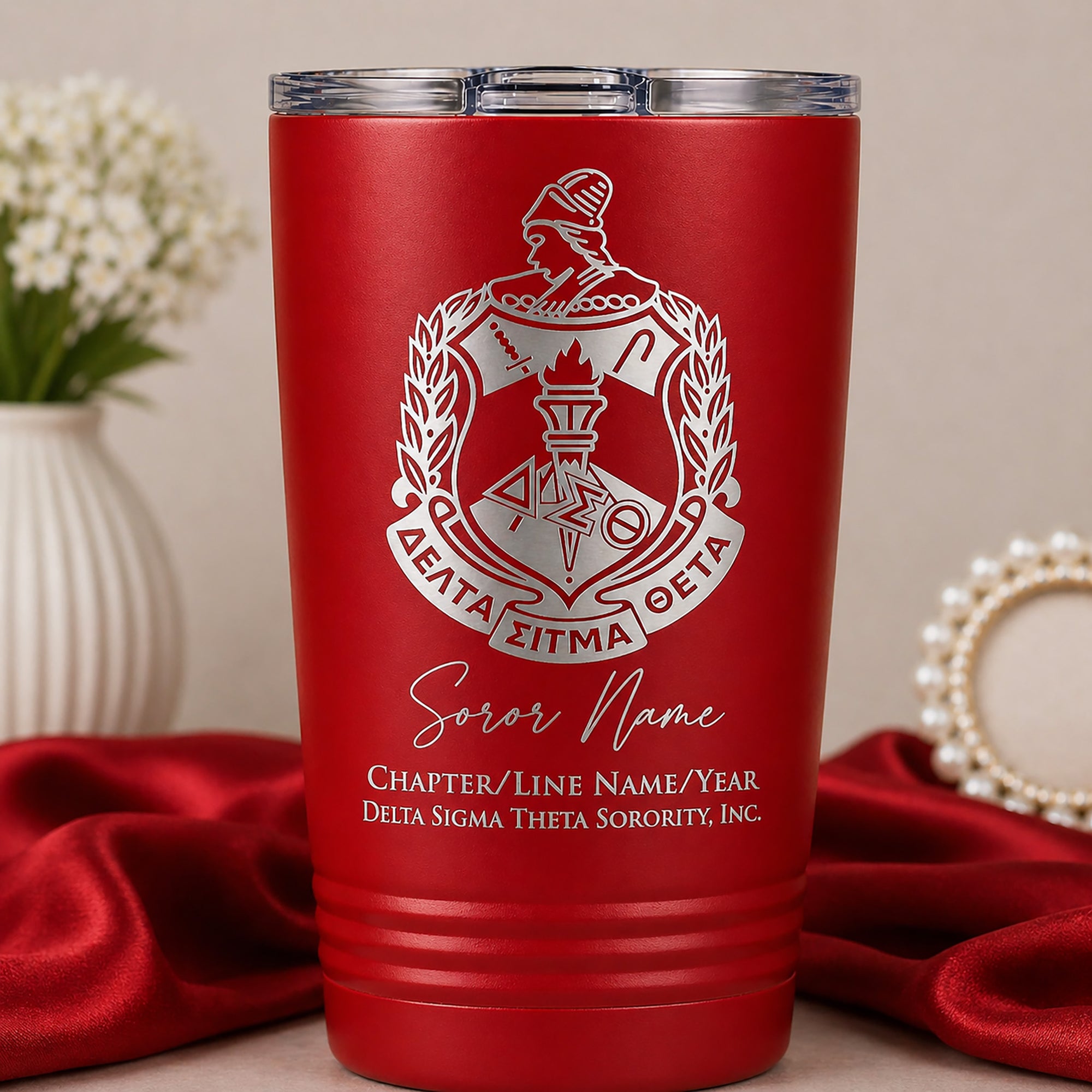 Red tumbler with white logo and text on a neutral background