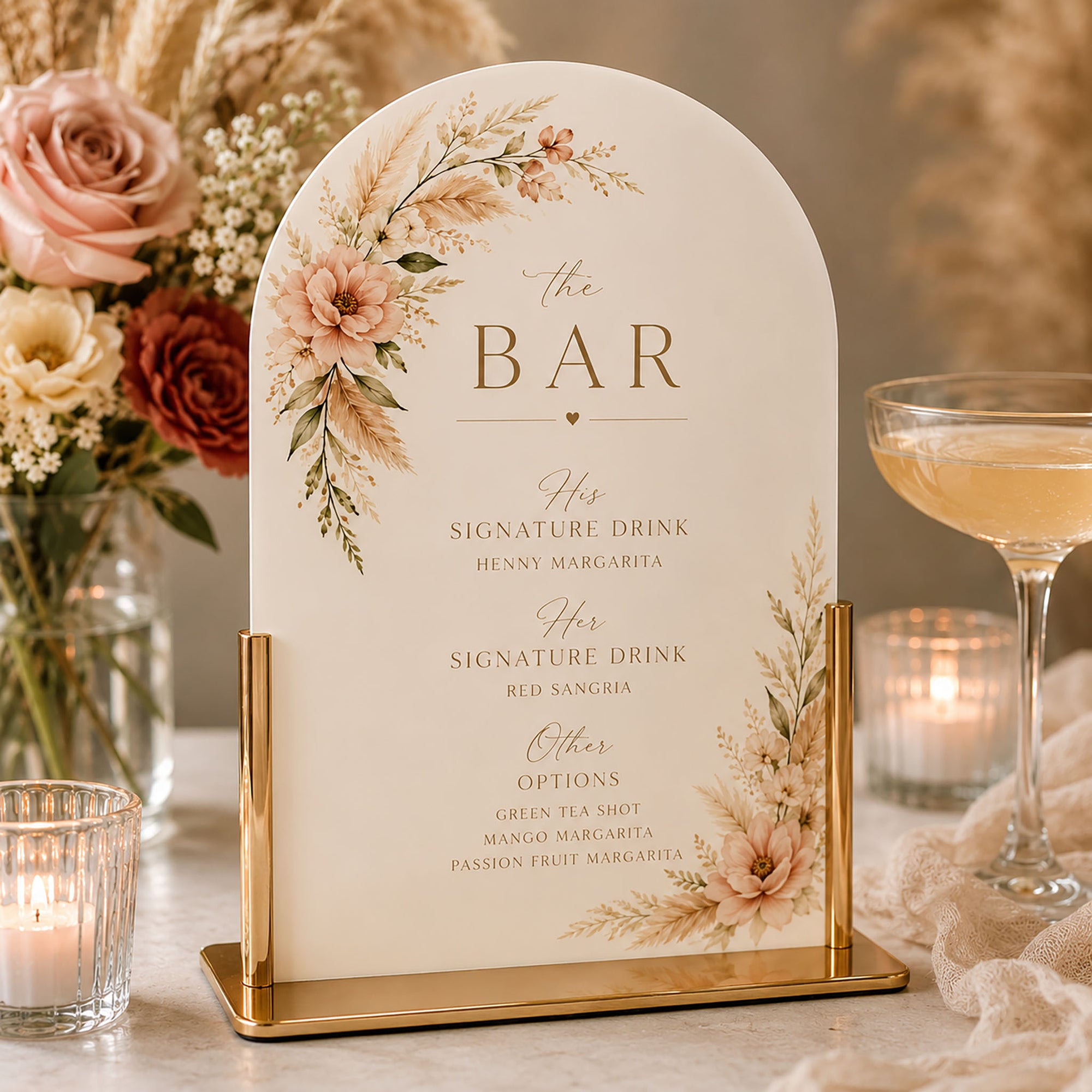 Decorative bar sign with floral design on a table with candles and cocktails.