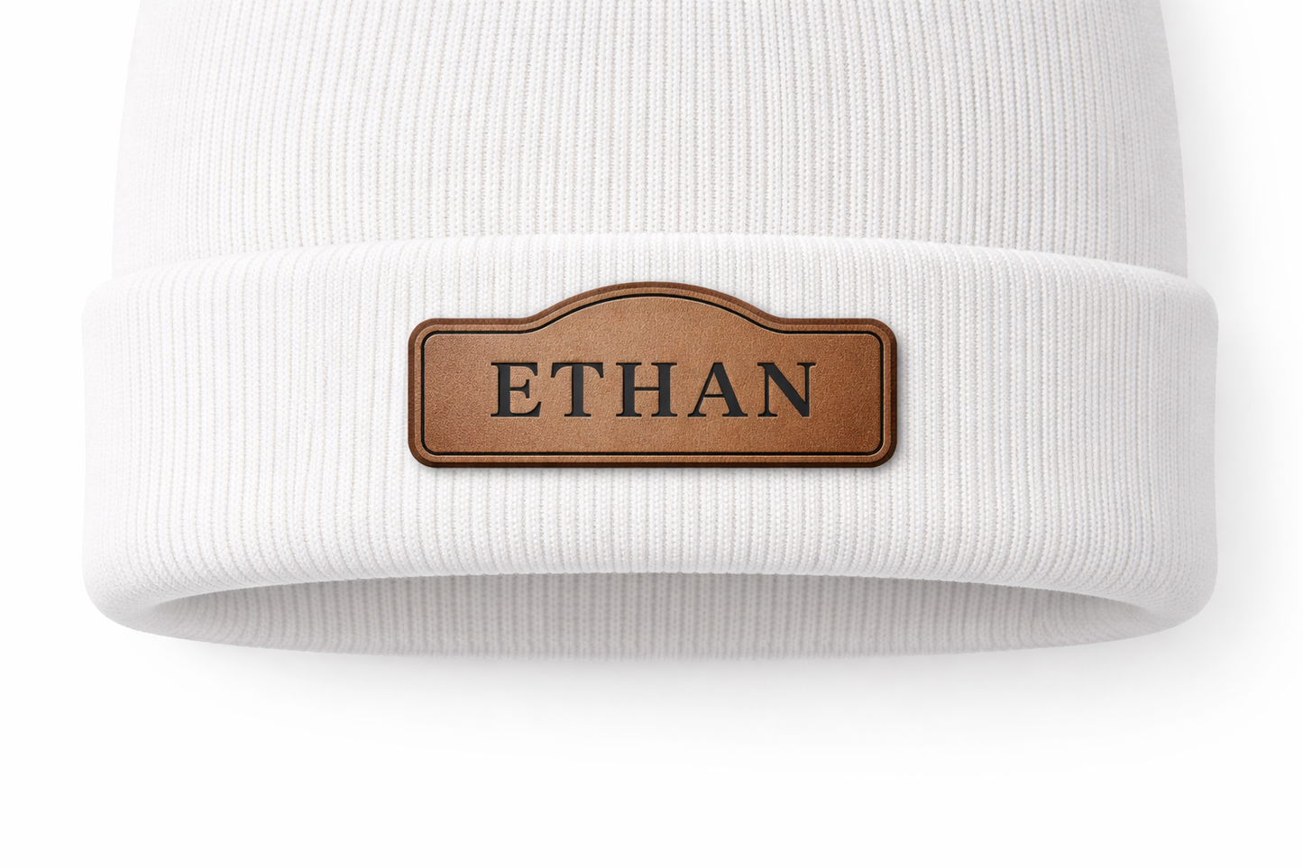 White beanie with a brown leather patch displaying 'ETHAN' on a white background