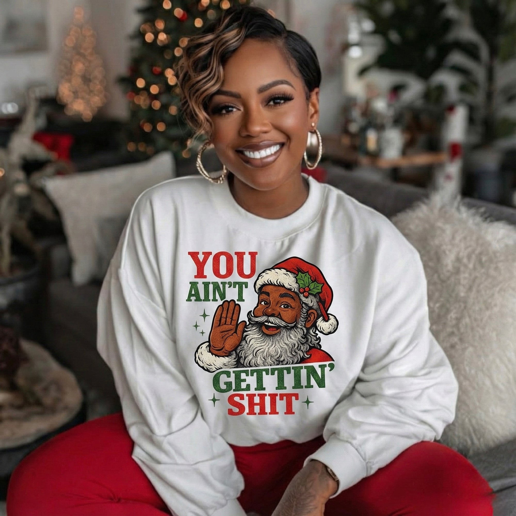 White crewneck sweatshirt with cartoon Santa graphic, raised hand, holiday text