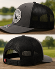 Heather gray trucker golf hat with black mesh sides and round golf ball logo patch
