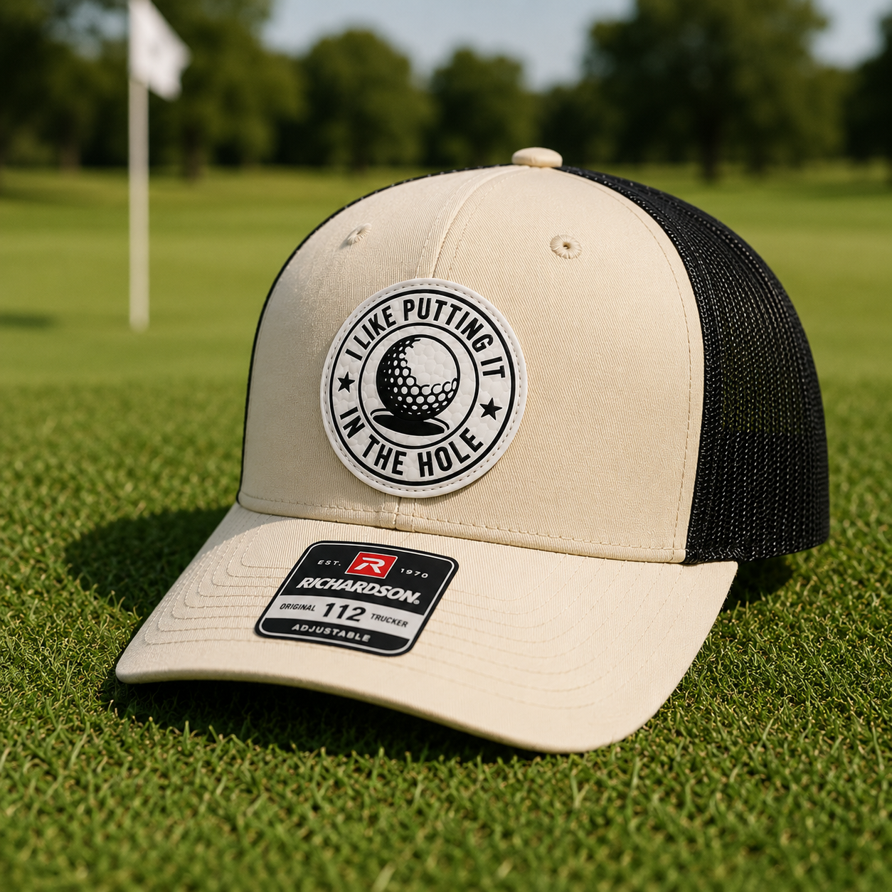 Birch and black trucker golf hat with tan front panel and circular 'I Like Putting' patch