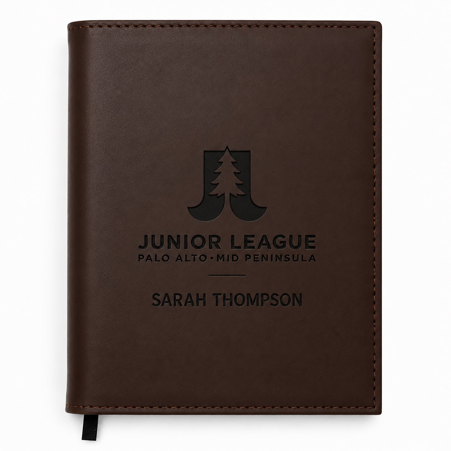 Brown leather notebook with engraved text and logo on a white background