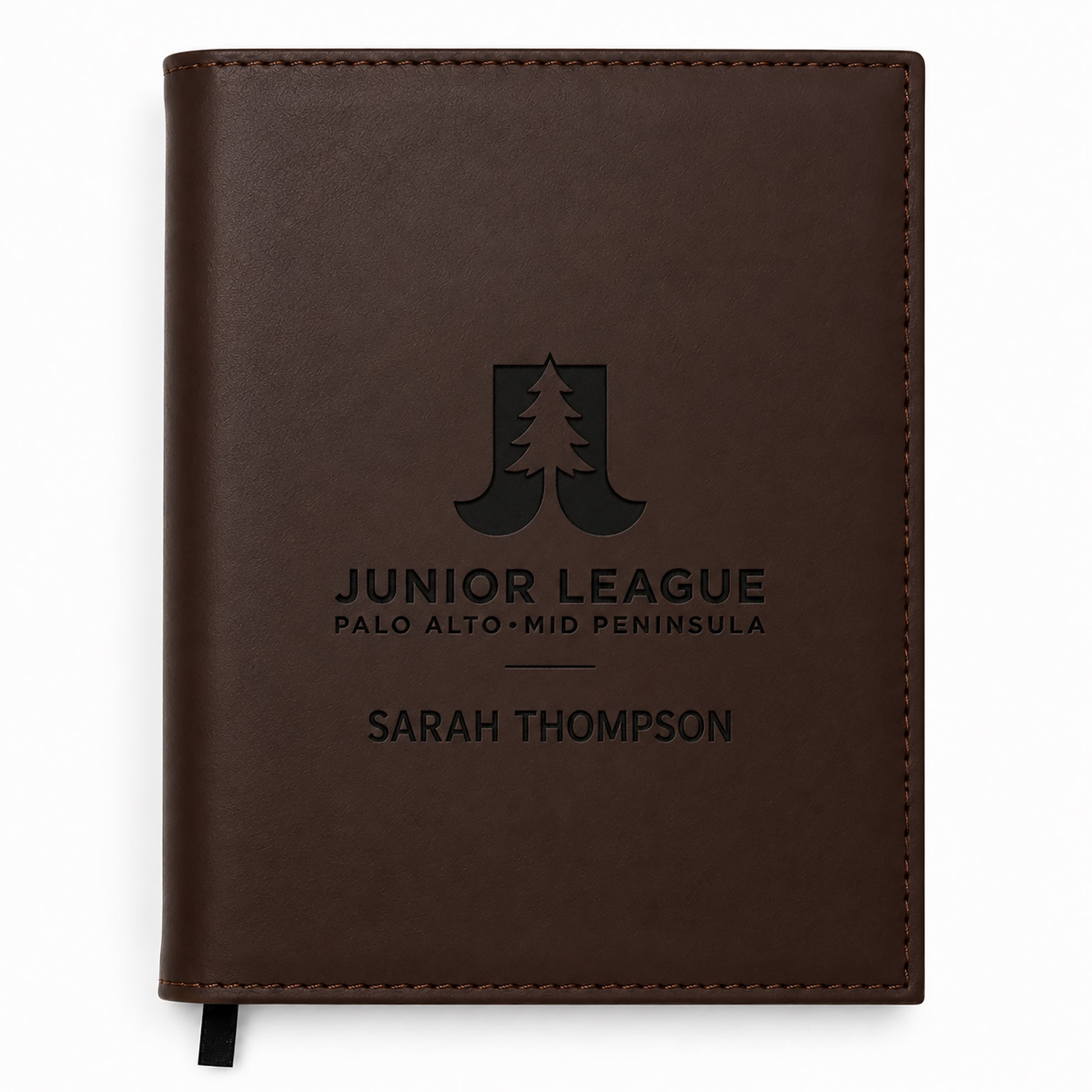 Brown leather notebook with engraved text and logo on a white background