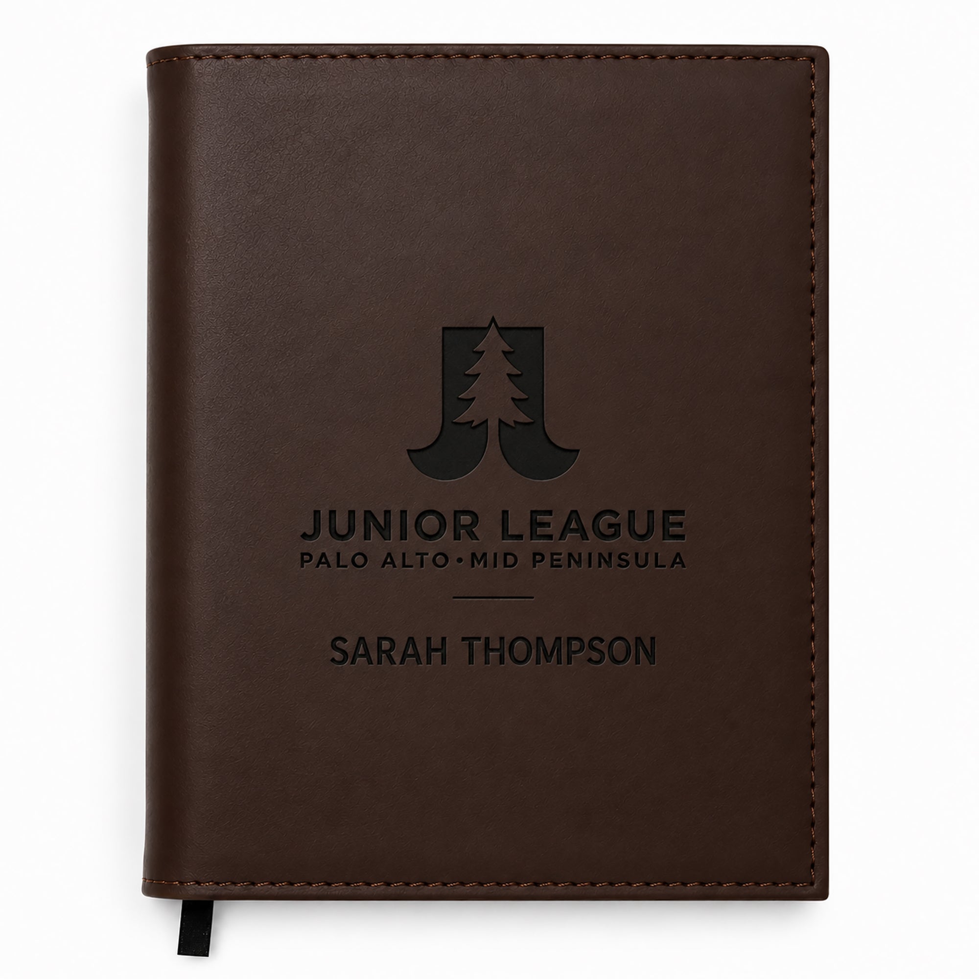 Brown leather notebook with engraved text and logo on a white background