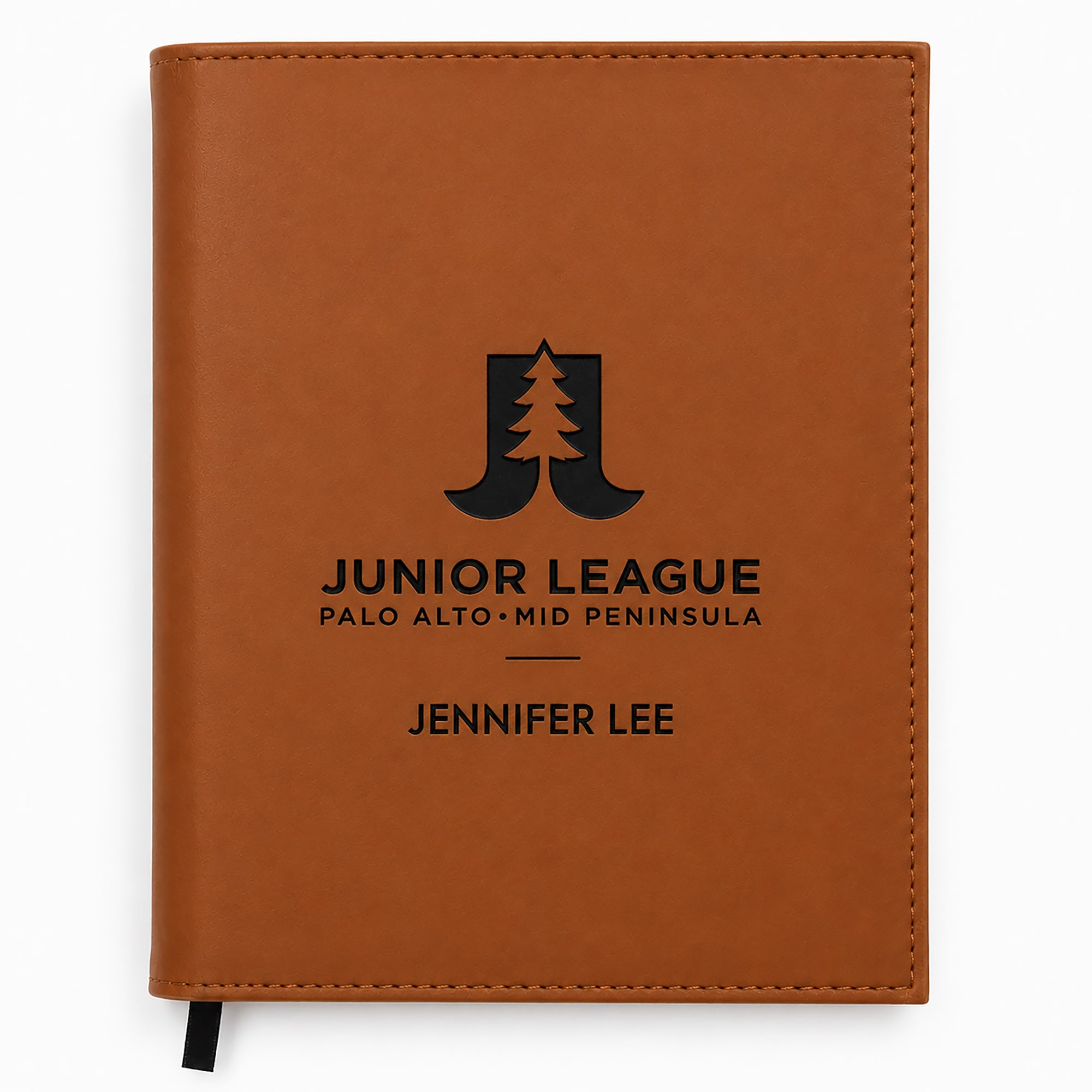 Brown notebook with 'Junior League' logo and text on a white background