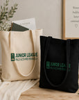 Natural and black tote bags with Junior League Palo Alto-Mid Peninsula logo on a wooden surface.