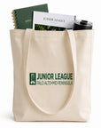 Tote bag with Junior League Palo Alto Mid Peninsula logo containing a notebook, book, and tumbler.