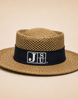 A straw fedora hat with a black band featuring the white 'JSU' logo, set against a solid beige background.