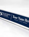 A custom Jacksonville State University name sign with a navy blue face, silver metal frame, and white text placeholders for a name and title, shown on a clean white background.