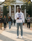 Black man wearing a Jackson State University Roar For Thee Cure White Hoodie on a college campus