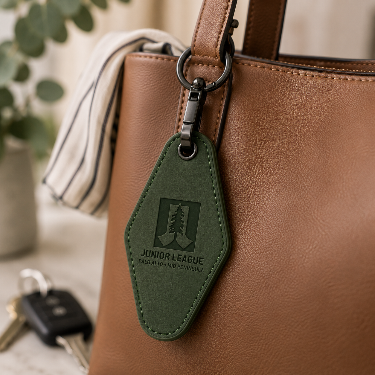 Close-up of black gunmetal swivel clip and keyring hardware on green engraved motel keychain