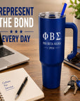 Blue Phi Beta Sigma mug on a desk with laptop, notebook, and keys.