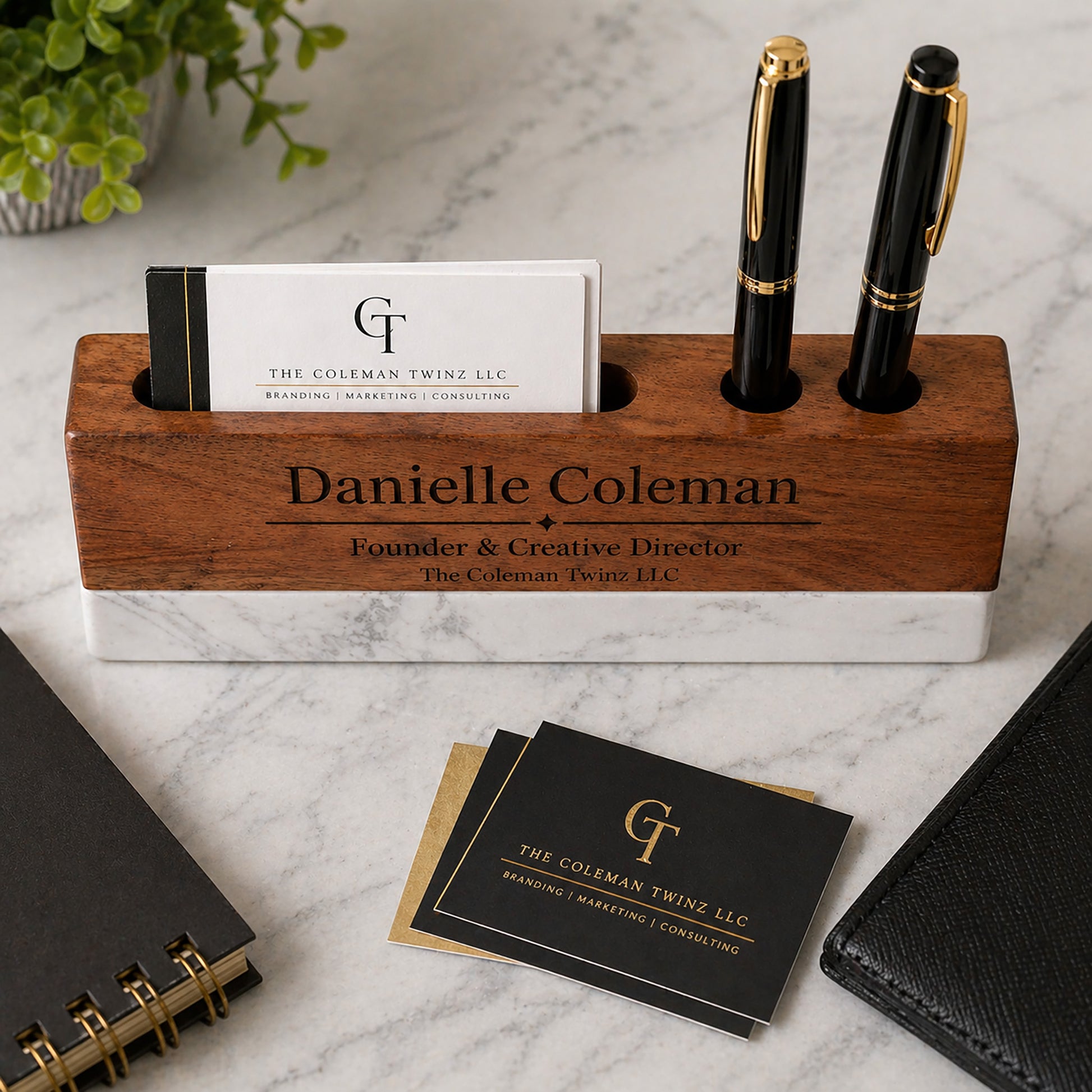 Wooden pen holder with personalized engraving on a marble surface with business cards and pens.