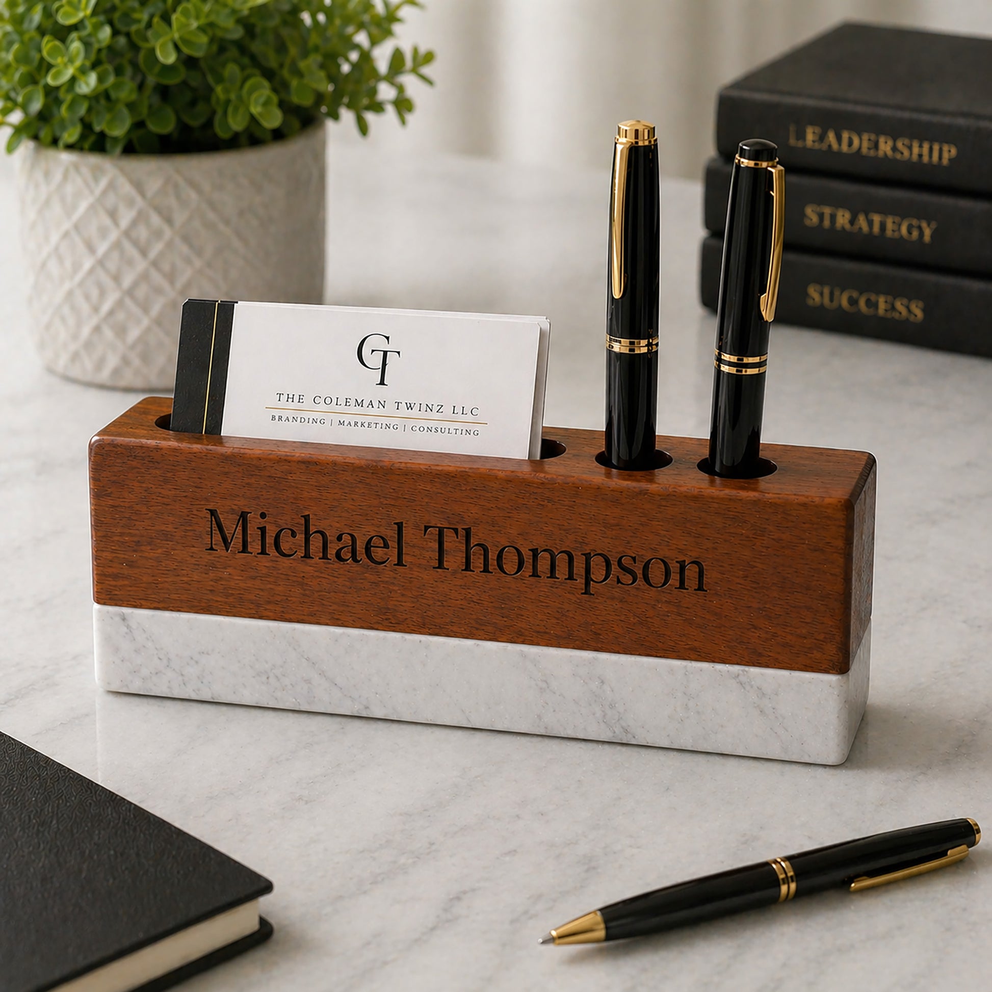 Personalized wooden pen holder with name 'Michael Thompson' on a marble surface with books and a plant in the background.