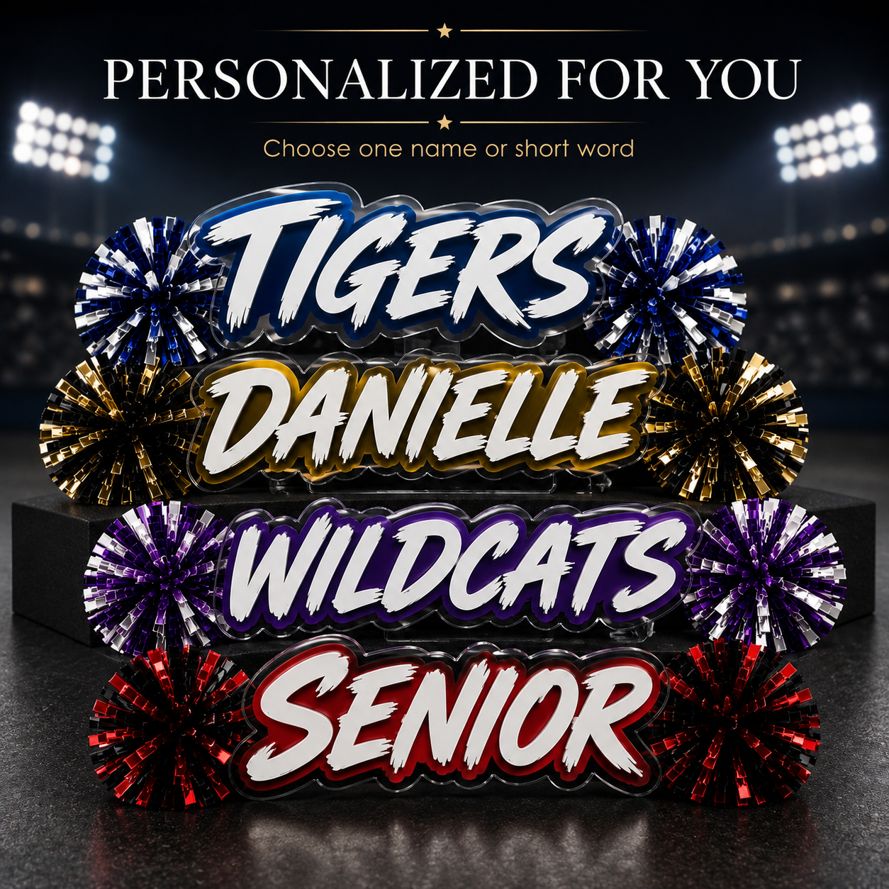 Personalized acrylic spirit stick with blue and white lettering plus red, purple, and gold pom-poms