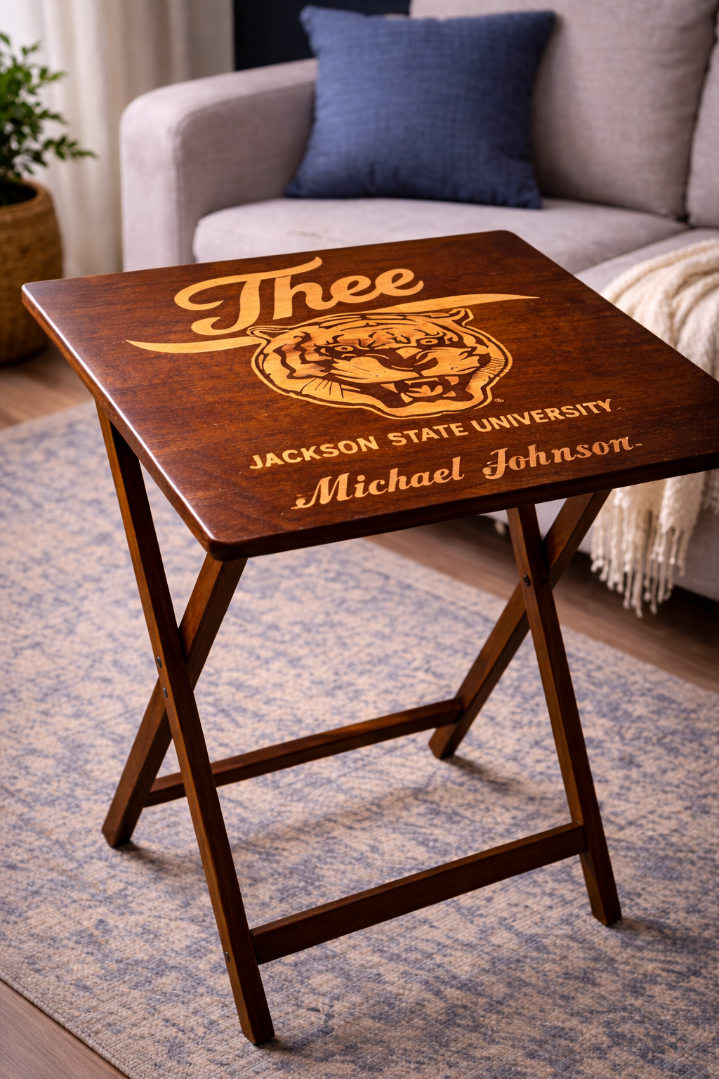 Dark wood folding tray table with engraved “J’thee,” tiger crest, and “John Michael Johnson”