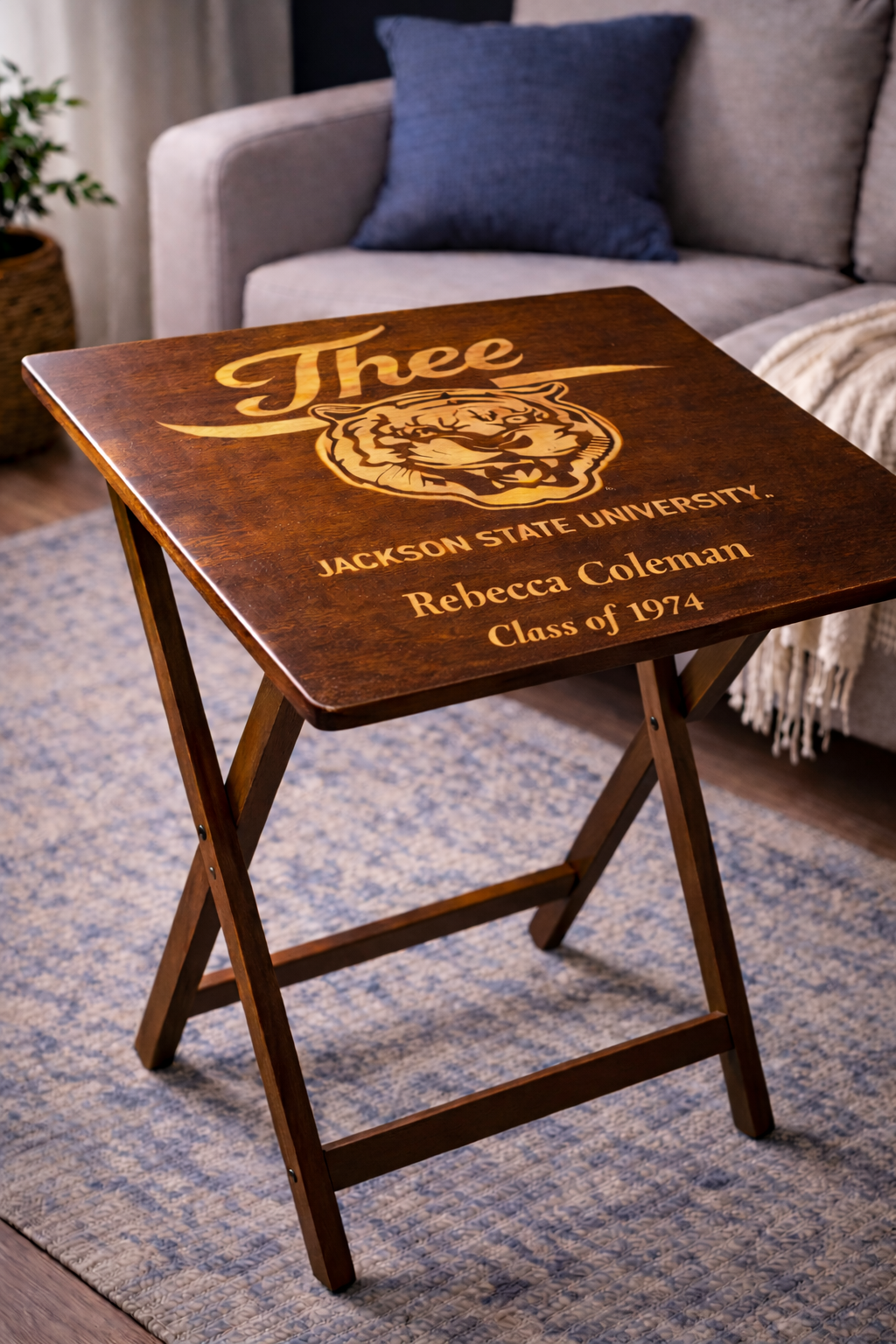 Dark wood folding tray table with engraved “J’thee,” tiger crest, “Rebecca Coleman,” and “Class of 1974”