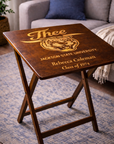 Dark wood folding tray table with engraved “J’thee,” tiger crest, “Rebecca Coleman,” and “Class of 1974”