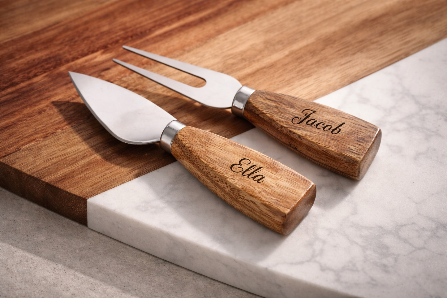 Closeup of personalized laser engraved cheese utensils on marble and wood cutting board